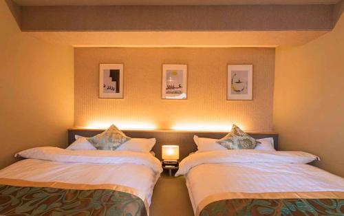 Dos camas en una habitación de hotel con dos en Lite House Shinsaibashi 4, en Osaka