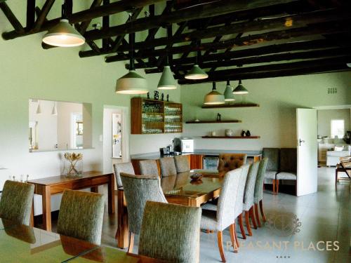 Pleasant Places By Sanaandi في Lidgetton: غرفة طعام مع طاولة وكراسي