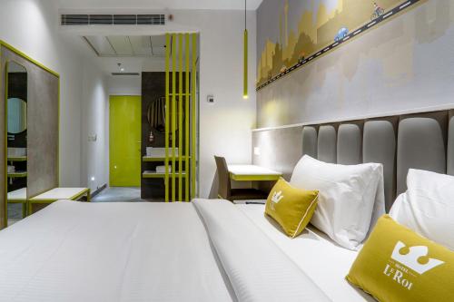 - une chambre avec un lit blanc et des oreillers jaunes dans l'établissement Le ROI Express Paharganj, à New Delhi