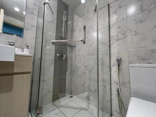 a shower with a glass door in a bathroom at Cozy & Quiet Studio in Dubai