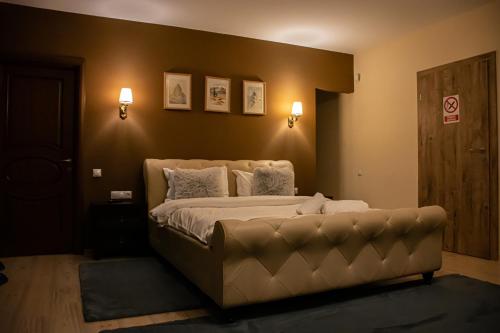 sypialnia z dużym łóżkiem i kanapą w obiekcie JANINE GARDEN w Braszowie