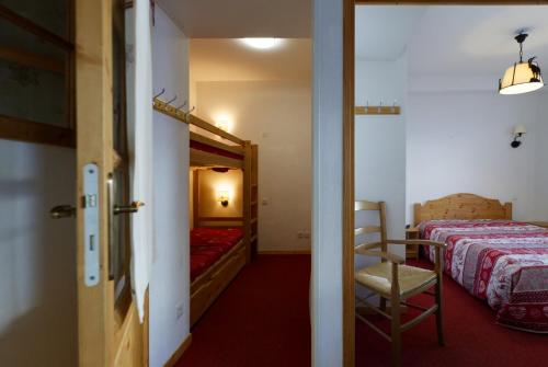 een slaapkamer met een bed, een stoel en een deur bij B406- Appartement 2 pieces cabine 6 personnes in Orcières