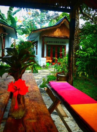a table with a red napkin on it in front of a house at Sumatra Orangutan Discovery Villa in Bukit Lawang