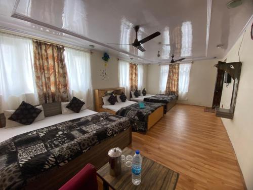 a room with three beds and a couch at Hotel Young Mamta in Srinagar