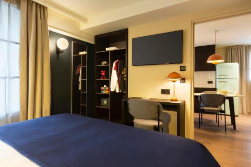 a bedroom with a bed and a desk and a table at RockyPop Grenoble Hotel in Grenoble