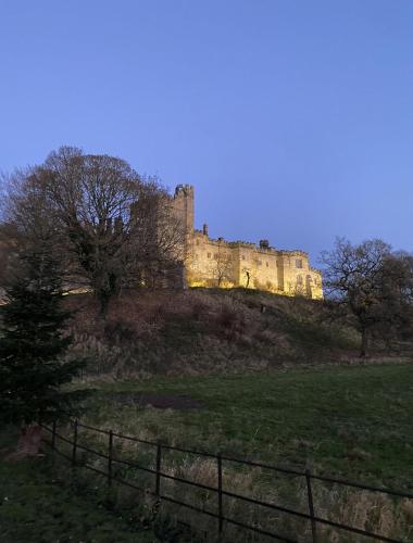a castle sitting on top of a hill at The Beeches - Chatsworth Apartment No 1 - Sleeps 4 in Baslow