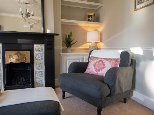 a living room with a chair and a fireplace at The Beeches - Chatsworth Apartment No 1 - Sleeps 4 in Baslow