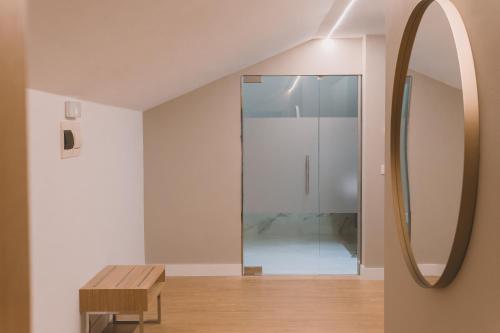 San SalvadorにあるHOTEL CANDORのガラス張りのシャワーと鏡が備わる客室です。