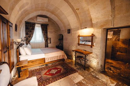 a bedroom with a bed in a stone room at Hanzade Cappadocia in Goreme