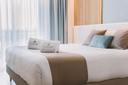 a bedroom with a large bed with two pillows on it at HOTEL CANDOR in A Lama