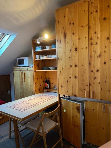 uma cozinha com armários de madeira e uma mesa num quarto em Deer Attic em Pila