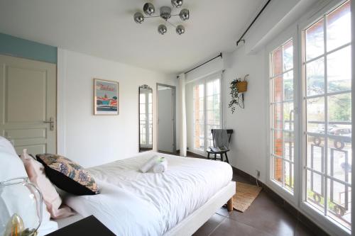 - une chambre avec un lit doté de draps blancs et de fenêtres dans l'établissement expat renting - Le Bistrot - St Cyprien - Parking, à Toulouse