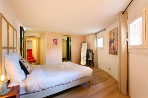 une chambre avec un grand lit blanc dans une pièce dans l'établissement expat renting - Le Bistrot - St Cyprien - Parking, à Toulouse