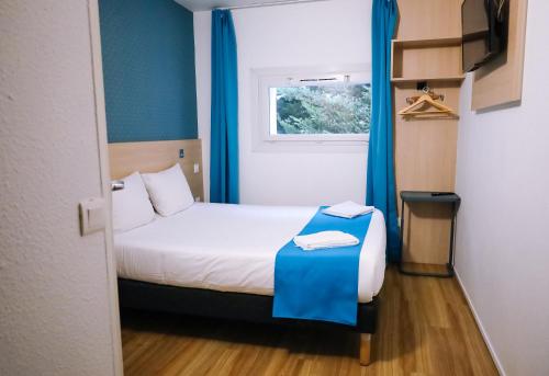 Cette petite chambre comprend un lit et une fenêtre. dans l'établissement Kyriad Direct Chilly-Mazarin, à Chilly-Mazarin