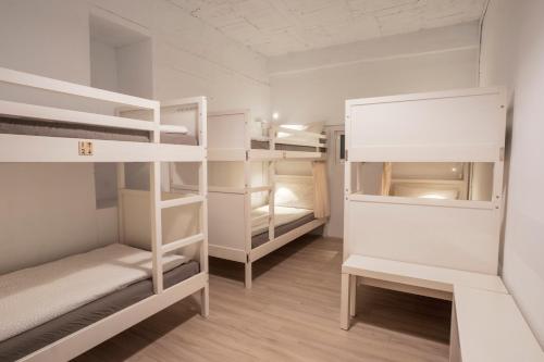 瑞芳區的住宿－瑞芳驛青旅民宿，一间设有白色双层床的房间