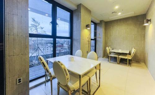 a dining room with a table and chairs and a window at Brown Dot Hotel Yangsan Seochang in Yangsan