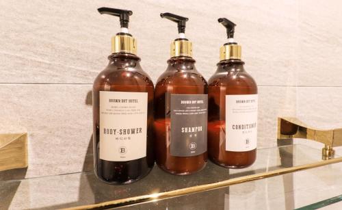 three bottles of honey sitting on a glass shelf at Brown Dot Hotel Yangsan Seochang in Yangsan