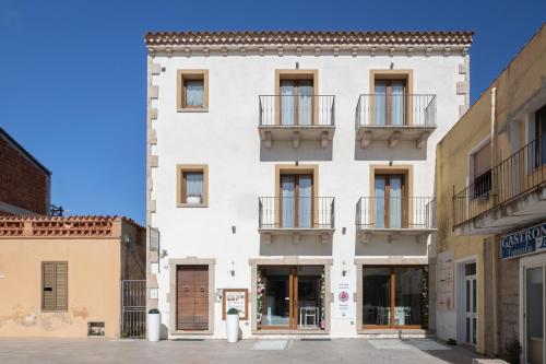 a white building with balconies on a street at La casa di Minnanna in Cannigione