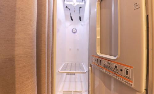 a small refrigerator with a pair of scissors in it at Brown Dot Hotel Yangsan Seochang in Yangsan
