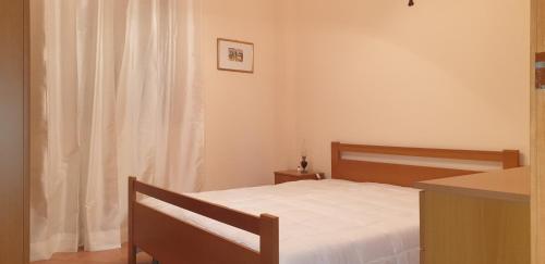 a bedroom with a bed with white sheets and a window at Bellona 319 in Comiso