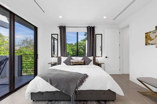 een slaapkamer met een groot bed en grote ramen bij Modern Villa w/ Resort Amenities & Salt Water Pool in Miami