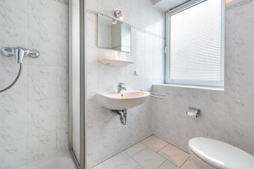 Baño blanco con lavabo y espejo en Villa Bella Vista - Meerblick 1, en Sassnitz