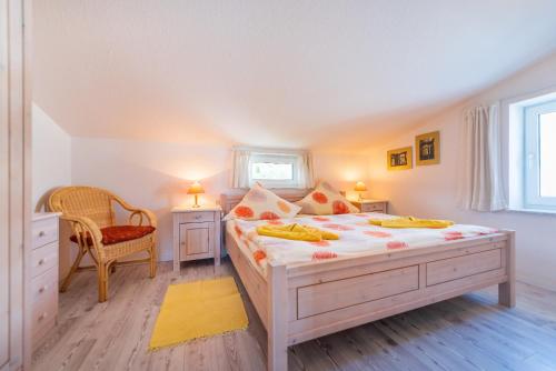 - une chambre avec un grand lit et une chaise dans l'établissement Villa Bella Vista - Meerblick 5, à Sassnitz