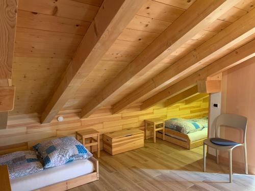 2 letti in una camera con soffitti in legno di Obereggen - Anna a Ega
