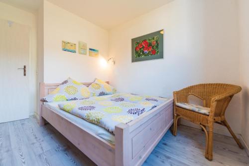1 dormitorio pequeño con 1 cama y 1 silla en Villa Bella Vista - Meerblick 4, en Sassnitz