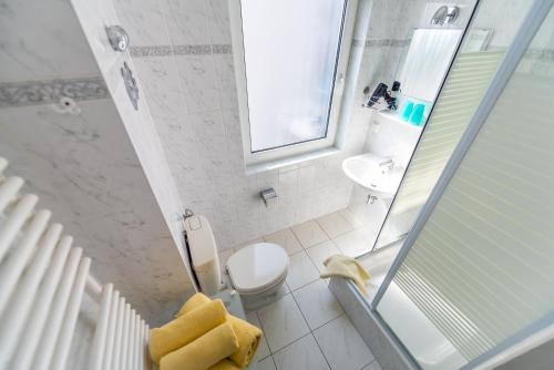 a white bathroom with a toilet and a sink at Villa Bella Vista - Meerblick 2 in Sassnitz