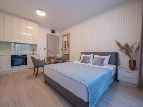 a bedroom with a large bed and a kitchen at CASA AL MARE RESIDENCE in Bečići