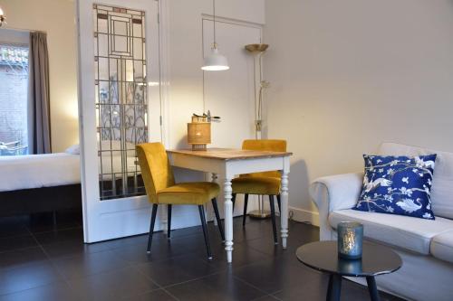 a living room with a table and chairs and a couch at Hotel Steeds aan Zee in Katwijk
