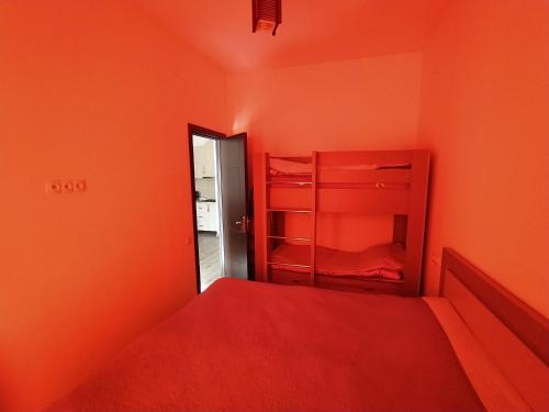 a bedroom with orange walls and a bunk bed at Bakuriani apartament in Bakuriani