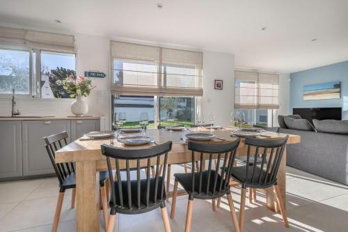 une cuisine et une salle à manger avec une table et des chaises en bois dans l'établissement 300m de la plage - Grande terrasse - 8 personnes, à Arzon