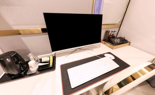 a desk with a computer monitor and a keyboard at Brown Dot Hotel Yangsan Seochang in Yangsan
