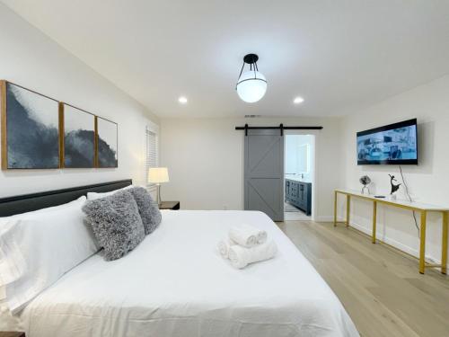 a bedroom with a large white bed and a desk at @ Marbella Lane – Contemporary Sophisticated Home in Sunnyvale