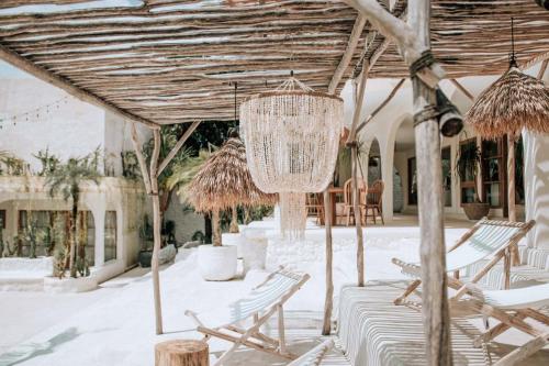 a chandelier hangs from an outdoor patio with chairs at Hotel Sages in Canggu