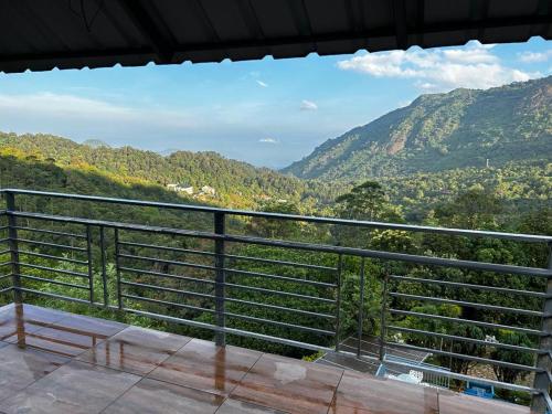 a balcony with a view of the mountains at Wild Elephant Resort in Kallar Vattiyar