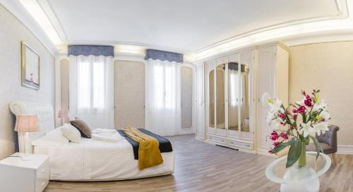 a large bedroom with a bed and a vase of flowers at Venice Dream Apartments in Venice