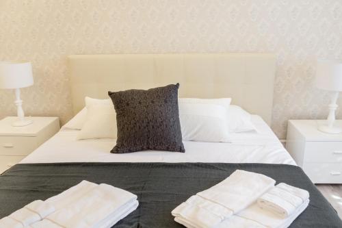 a bedroom with a white bed with two lamps and towels at Venice Dream Apartments in Venice
