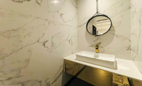 a white bathroom with a sink and a mirror at Brown Dot Hotel Yangsan Seochang in Yangsan