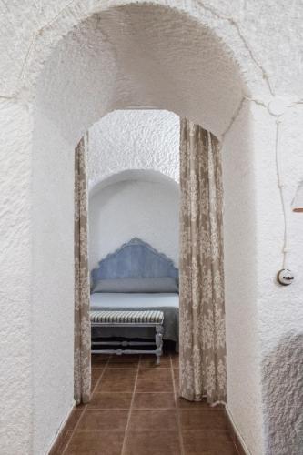 a bedroom with a bed in a white wall at Casa Cueva Picoesquina in Guadix