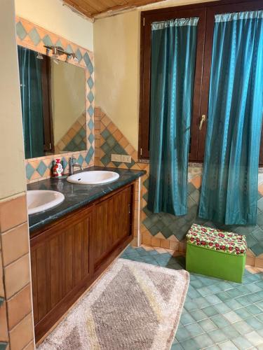 uma casa de banho com 2 lavatórios e um espelho grande em La casa di Simona em Telti