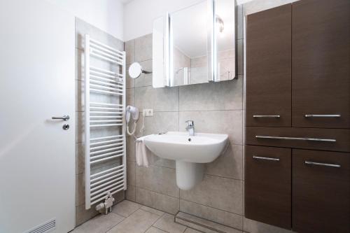 La petite salle de bains est pourvue d'un lavabo et d'un miroir. dans l'établissement Wohnpark am Mühlenteich App 28 Sandkiste, à Timmendorfer Strand