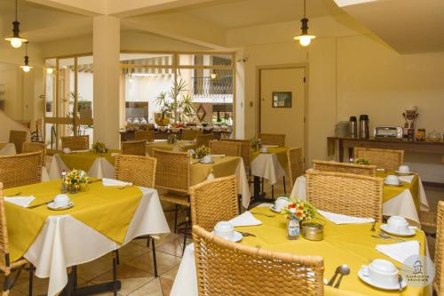 un ristorante con tavoli e sedie con tovaglia gialla di Solara Hotel a São João del Rei