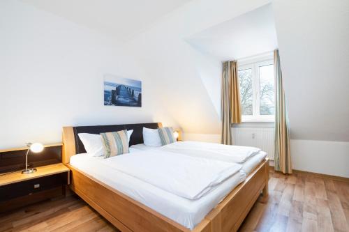 een slaapkamer met een groot bed en een raam bij Wohnpark am Mühlenteich App 35 Ostseehafen in Timmendorfer Strand
