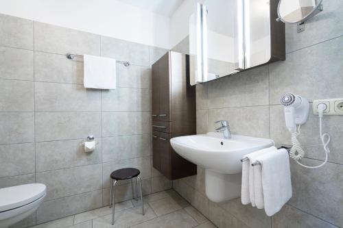een badkamer met een wastafel, een toilet en een spiegel bij Wohnpark am Mühlenteich App 35 Ostseehafen in Timmendorfer Strand