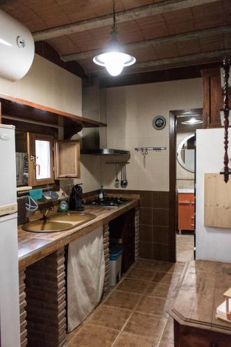 a kitchen with a sink and a refrigerator at Casa Cueva Picoesquina in Guadix