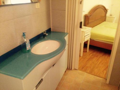 baño con lavabo y habitación con cama en Etruscan residence Perugia, en Pianello