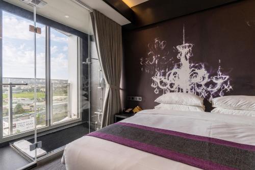Un dormitorio con una cama y una ventana grande. en Royal Roi Hotel, en Taichung